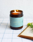 Bougie Collection Botanique 'Cyprès et Figue' en bocal verre ambré avec cire crème fondue et étiquette vert d'eau