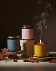 Gros plan du coffret Chaleur d’automne montrant pots en verre ambré et couvercles dorés avec étiquettes florales