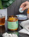 Close-up of Hinoki Fragrance Set reed diffuser with amber glass and soft soy wax glow