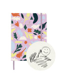 Garden Sketchbook with lilac matte cover adorned by abstract floral and bird motifs, elastic band closure, and fabric bookmark
