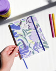 Vue plongeante du Mirage Agenda non daté avec couverture florale pastel, élastique bleu roi et marque-page assorti