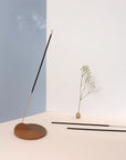 An incense stick burning slowly in an incense holder