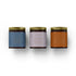 Spicy Collection candle gift set in amber glass jars with golden ribbed lids, minimalist white background