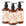 Three amber glass bottles of Bergamot and Neroli Petals hand soap with black pumps on a white background