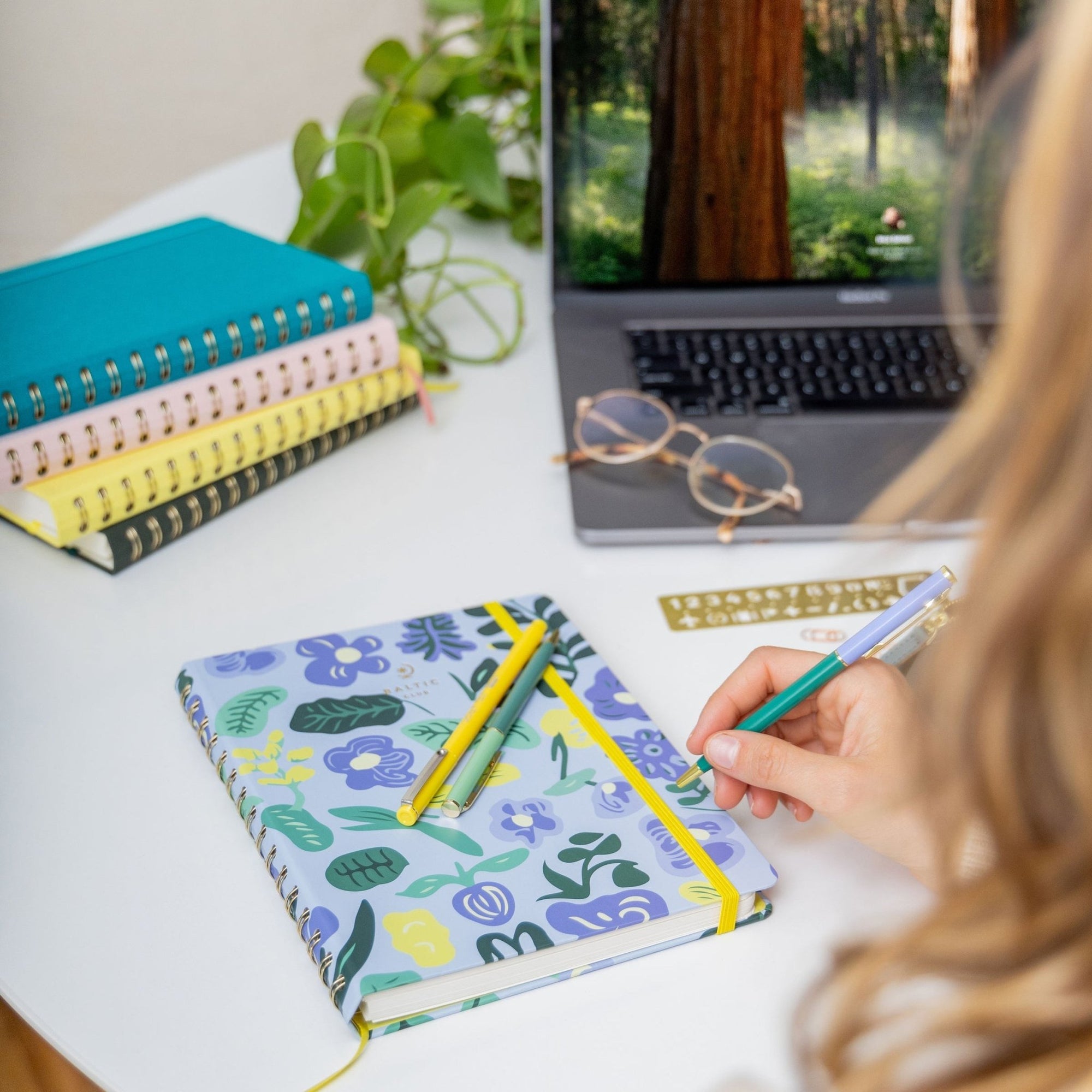 Zoom sur l'Agenda non daté Feroé Bleu avec reliure spirale dorée, motifs floraux et élastique jaune vif