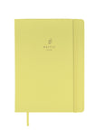 Carnet doux vert anis pâle avec logo embossé discret et élastique assorti sur fond blanc