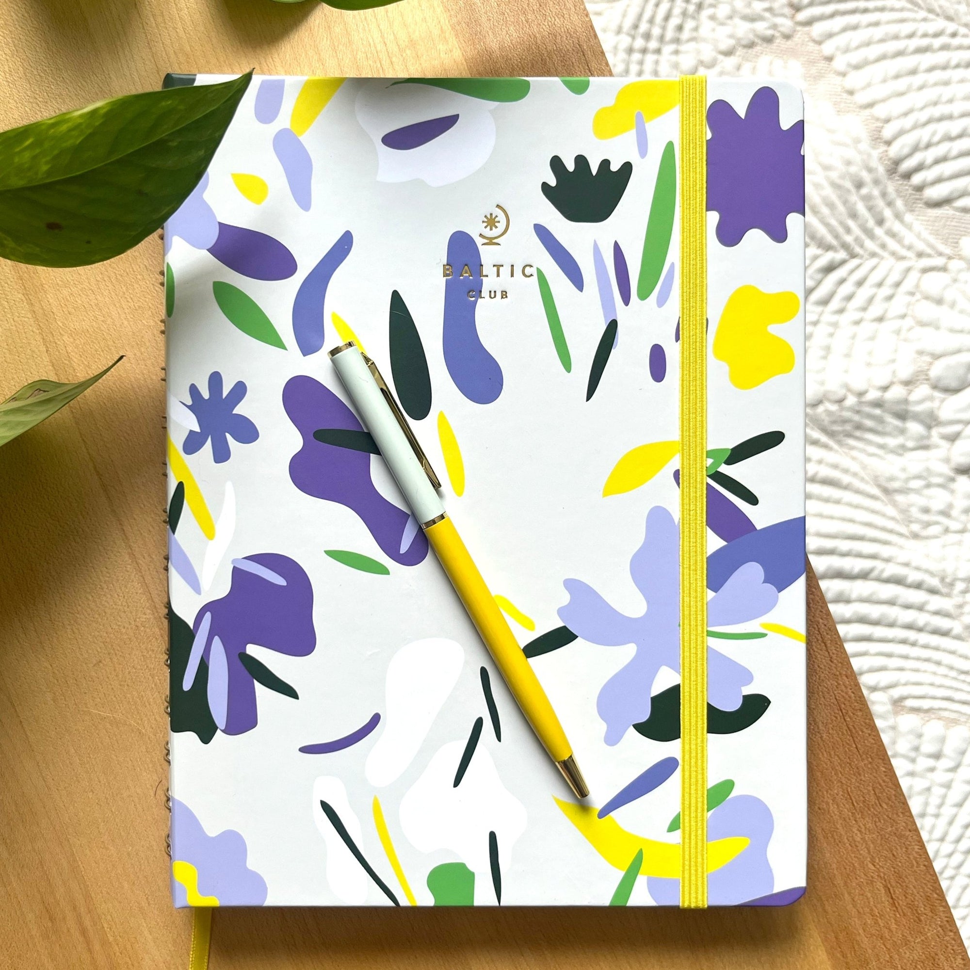 Carnet à dessins Présage en vue plongeante, couverture abstraite violet lavande et vert forêt avec logo doré Baltic Club et élastique jaune