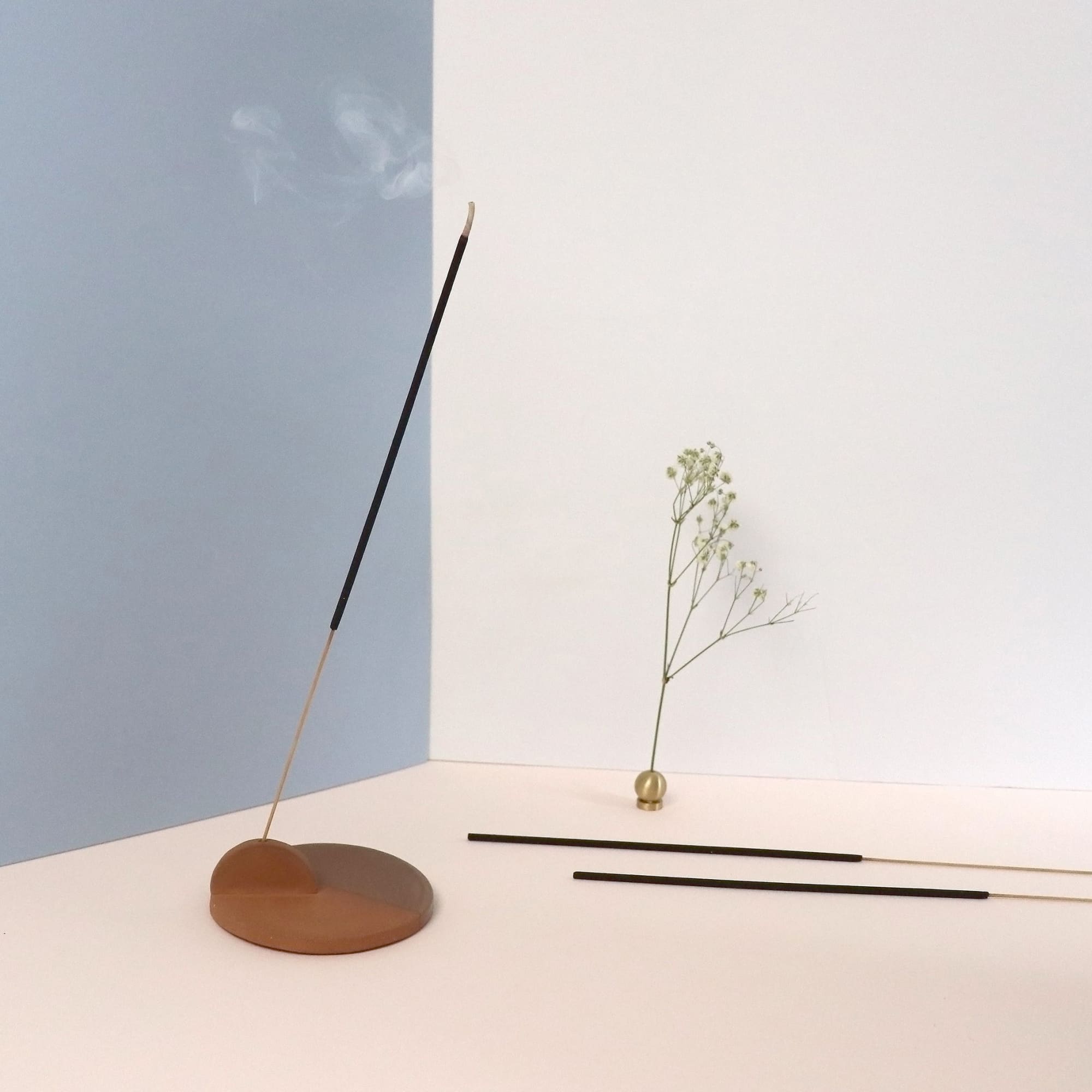 An incense stick burning slowly in an incense holder